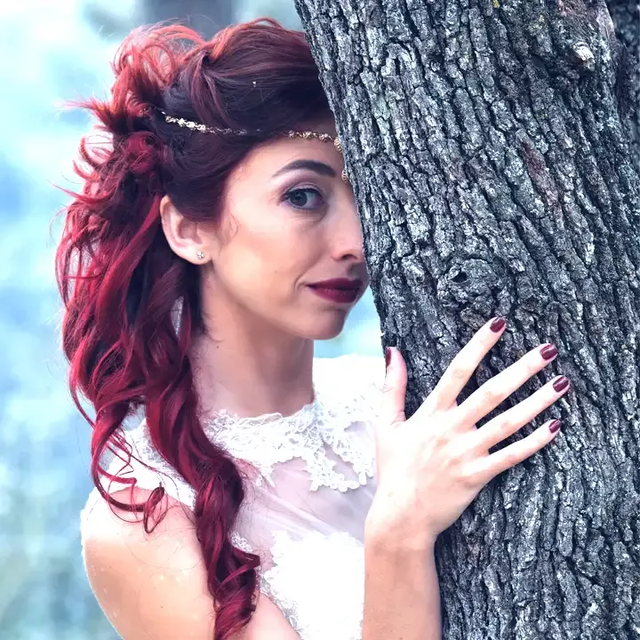 Bridal hairstyle: red hair pinned up at the side with long curls, jewelled headband