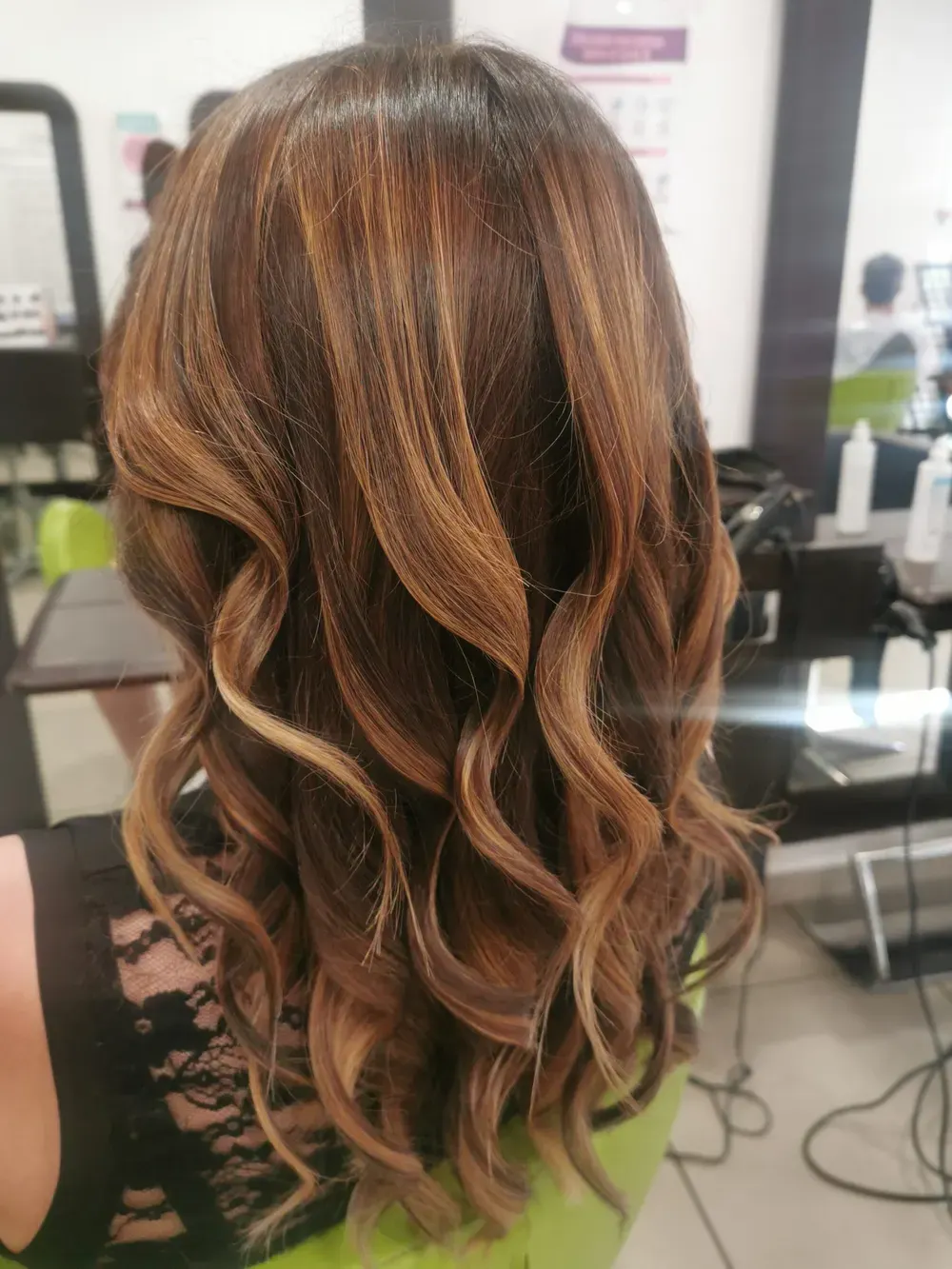 Caramel foilyage on long curly hair, in the salon